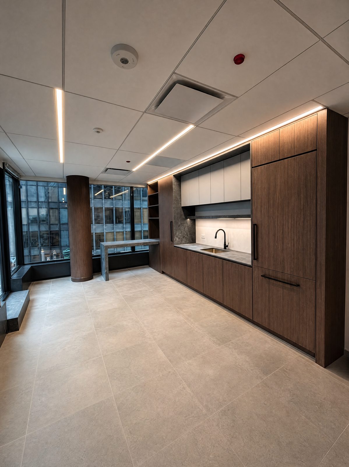 Office kitchenette with dark oak tall cabinets, white upper cabinets and a stone counter by floor-to-ceiling windows